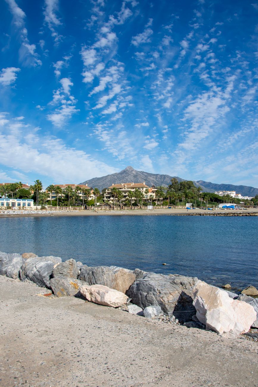 Marbella coastline with calm water and mountain in the background